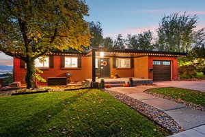 Single story home featuring brick siding, an attached garage, and a lawn