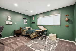 Bedroom with dark colored carpet and recessed lighting