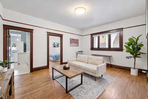 Living room featuring light wood-style flooring and a textured ceiling