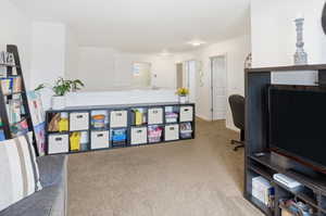 Office space with light colored carpet and baseboards