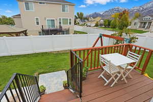 Deck featuring a residential view, a fenced backyard, outdoor dining area, a mountain view, and a gazebo