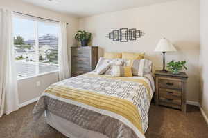 Bedroom featuring dark colored carpet and baseboards