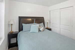 Carpeted bedroom featuring a closet