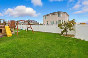 Fenced backyard featuring a playground