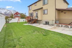Back of property with stucco siding, a fenced backyard, and a mountain view
