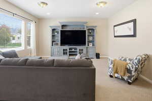 Carpeted living area featuring baseboards and recessed lighting