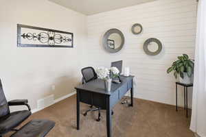 Office area featuring carpet and wood walls