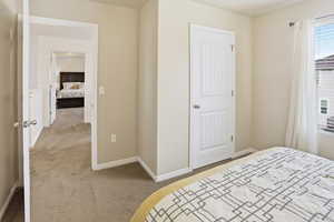 Bedroom with light colored carpet and baseboards
