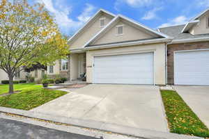 View of front of house with stone siding, stucco siding, driveway, and a front yard