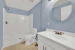 Bathroom with a paneled ceiling, vanity, a shower, and light floors