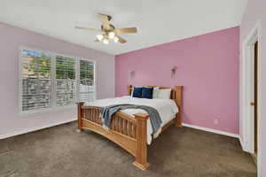 Bedroom with dark carpet and ceiling fan
