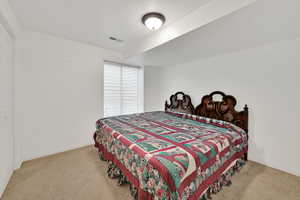 Bedroom with baseboards and light carpet