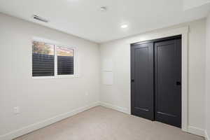 Unfurnished bedroom with carpet flooring, a closet, and recessed lighting
