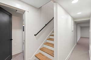 Stairway with carpet floors and recessed lighting