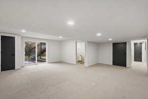 Below grade area featuring light colored carpet and recessed lighting