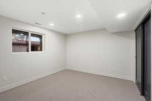 Unfurnished bedroom with light colored carpet and recessed lighting