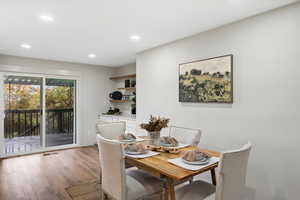 Dining area with light wood finished floors and recessed lighting