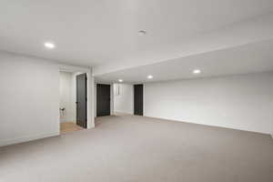 Finished basement with recessed lighting and light colored carpet