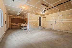 Garage featuring a garage door opener and a workshop area