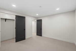 Unfurnished bedroom featuring light colored carpet, recessed lighting, and a closet