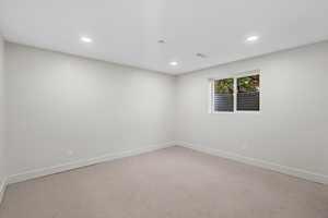 Empty room featuring light carpet and recessed lighting