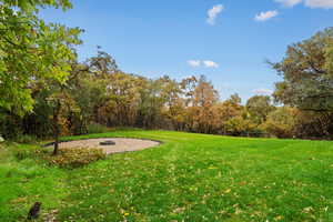 View of green lawn featuring a view of trees