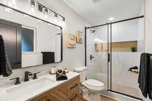 Primary Bathroom with a marble finish shower, vanity, and recessed lighting