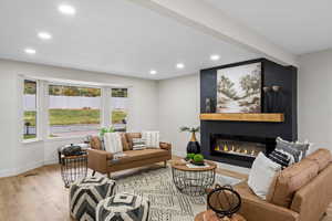 Living area with wood finished floors, recessed lighting, and a large fireplace