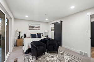 Primary Bedroom with a barn door, carpet flooring, and recessed lighting