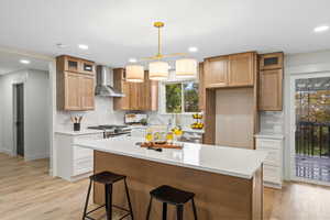 Kitchen featuring a breakfast bar, tasteful backsplash, decorative light fixtures, a center island, and brown cabinets
