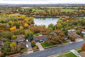 Aerial view of residential area with a nearby body of water and a tree filled landscape