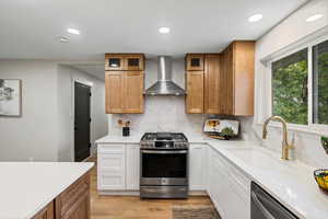 Kitchen with brown cabinets, appliances with stainless steel finishes, recessed lighting, decorative backsplash, and light wood finished floors