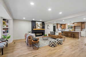 Living area featuring recessed lighting, light wood-style floors, and a large fireplace