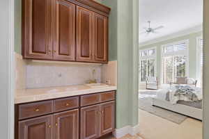 Bar with sink between primary bedroom and walk-in closet. Next to primary suite's private patio.
