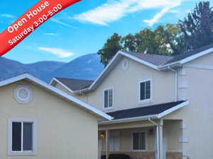 View of front facade featuring stucco siding, a mountain view, and a front yard