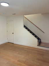 Staircase with wood finished floors and baseboards