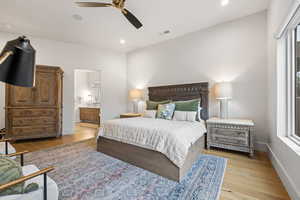 Bedroom with light wood-type flooring, recessed lighting, a ceiling fan, and ensuite bath