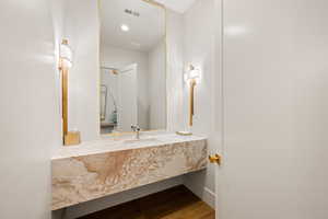 Half bath featuring dark wood finished floors and vanity