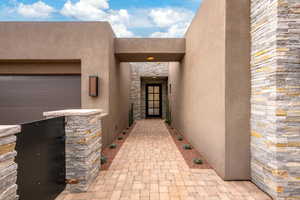 Doorway to property with stucco siding and stone siding