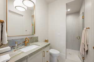 Full bath with vanity, a shower stall, and tile patterned flooring