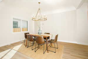 Dining room with light wood-style floors and a chandelier