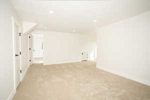 Empty room with recessed lighting and light colored carpet