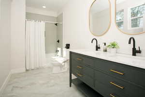 Full bath featuring shower / bath combination with curtain, double vanity, and light marble finish flooring