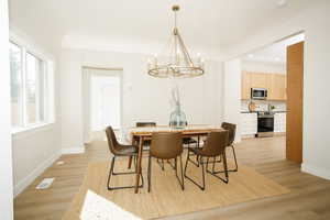 Dining room featuring a chandelier, light wood-style floors, and recessed lighting