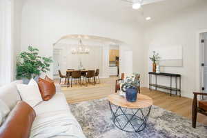 Living area featuring arched walkways, light wood-style floors, recessed lighting, a chandelier, and ceiling fan