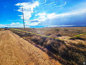 View of dirt / gravel road with a view of rural / pastoral area