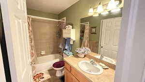 Full bath featuring shower / bathtub combination with curtain, vanity, and tile patterned floors