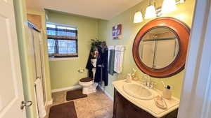 Bathroom featuring vanity, a stall shower, and light tile patterned flooring