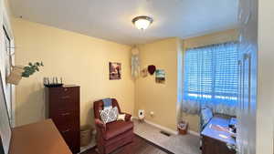 Carpeted home office featuring baseboards