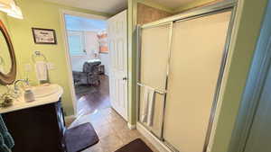 Full bath featuring a stall shower, vanity, light tile patterned floors, and a textured ceiling